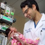Dr. Hackam holding a baby in the hospital