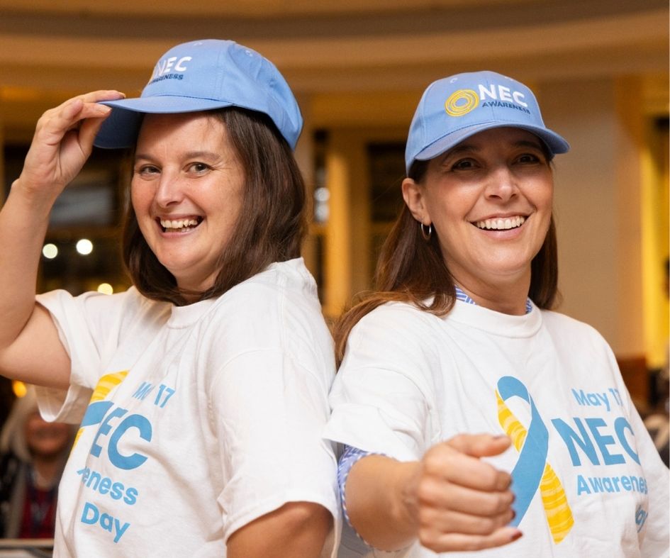 two women posing in NEC Awareness merch