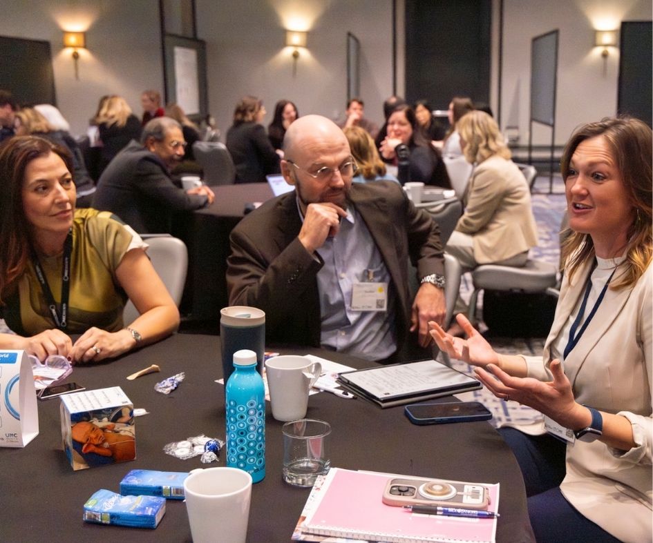 people speaking at table in ballroom