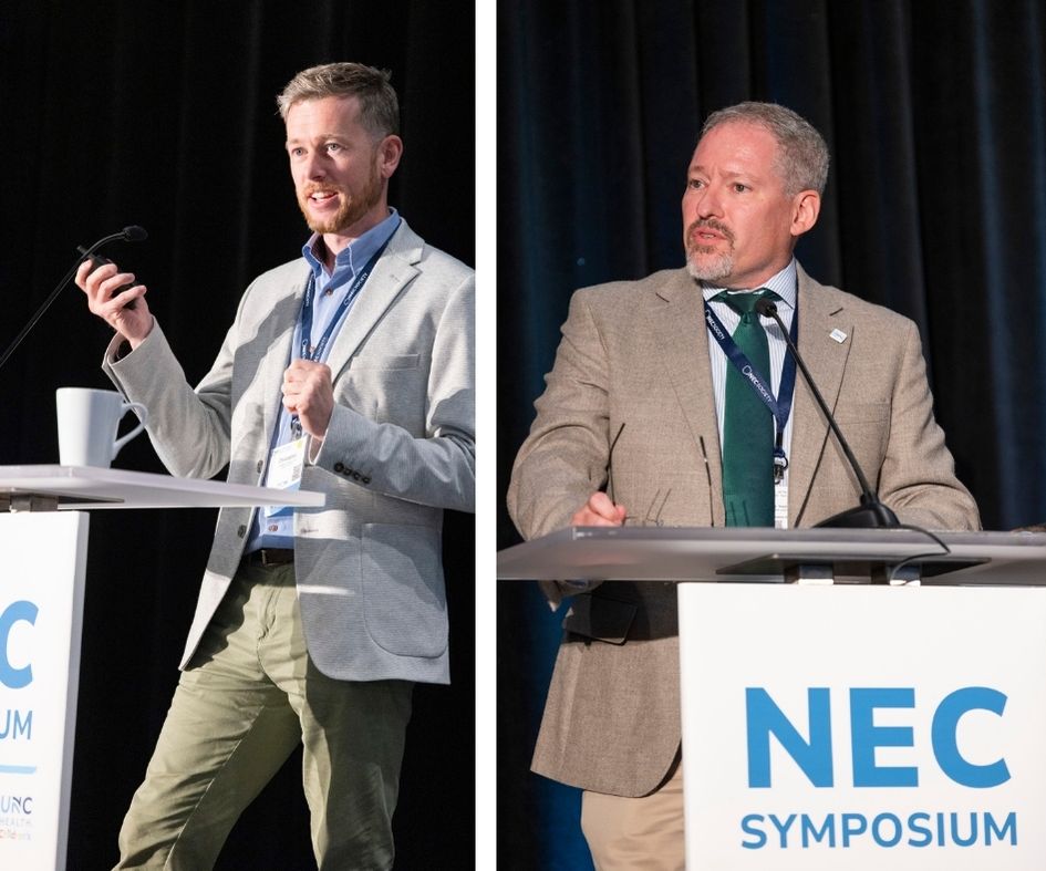 two men standing at NEC Synmposium podium