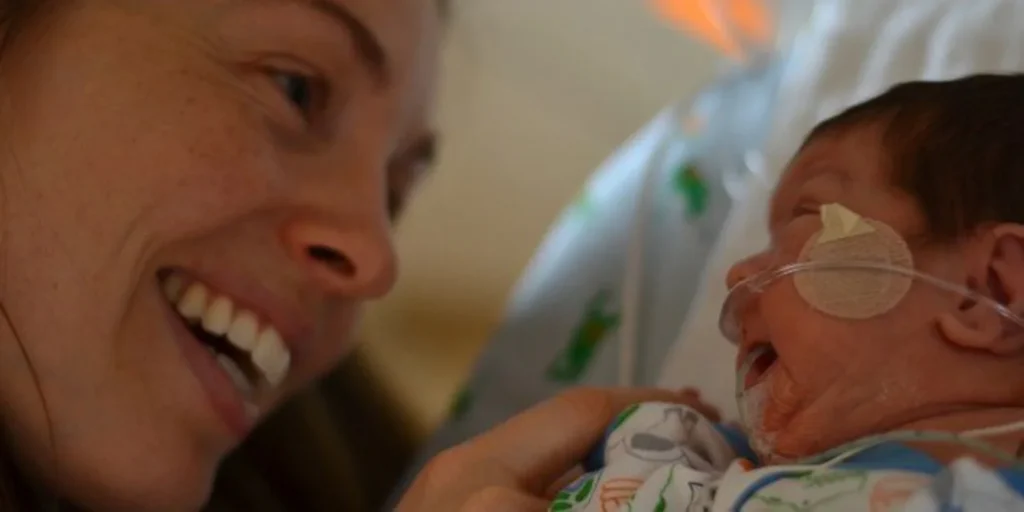 Mom smiling at her NICU babu
