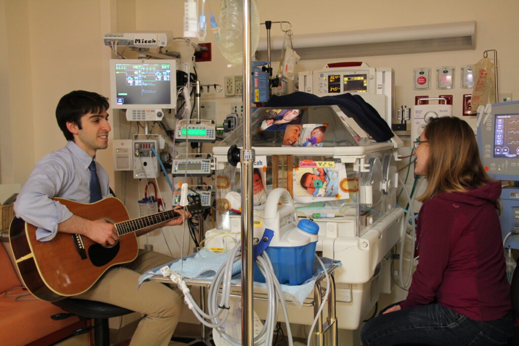 Dad playing guitar for hi sbaby in the NICU