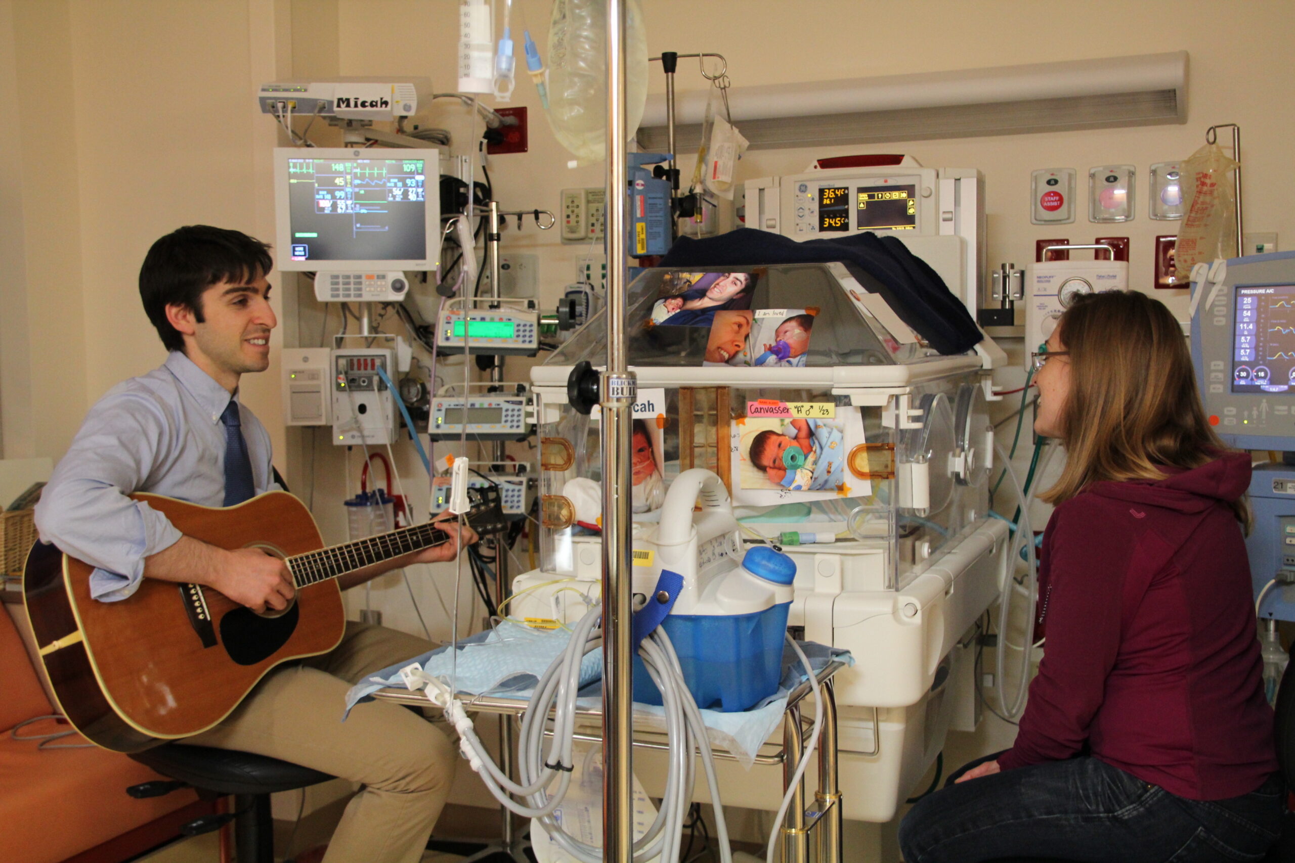 Dad playing guitar for hi sbaby in the NICU